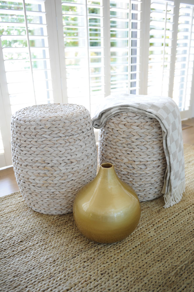 two woven stools on seagrass with gold vase