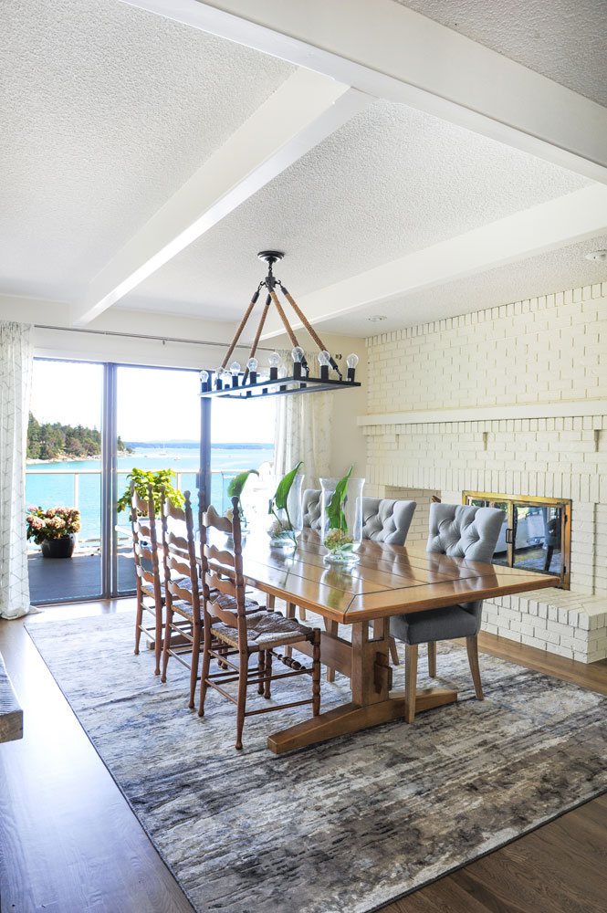 Dining room with mix of wood and tufted chairs and view to ocean