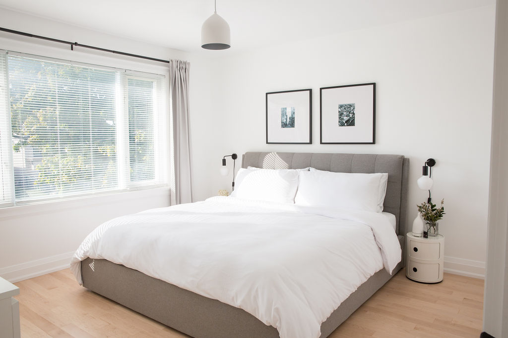 Bedroom with grey headboard and white bedding