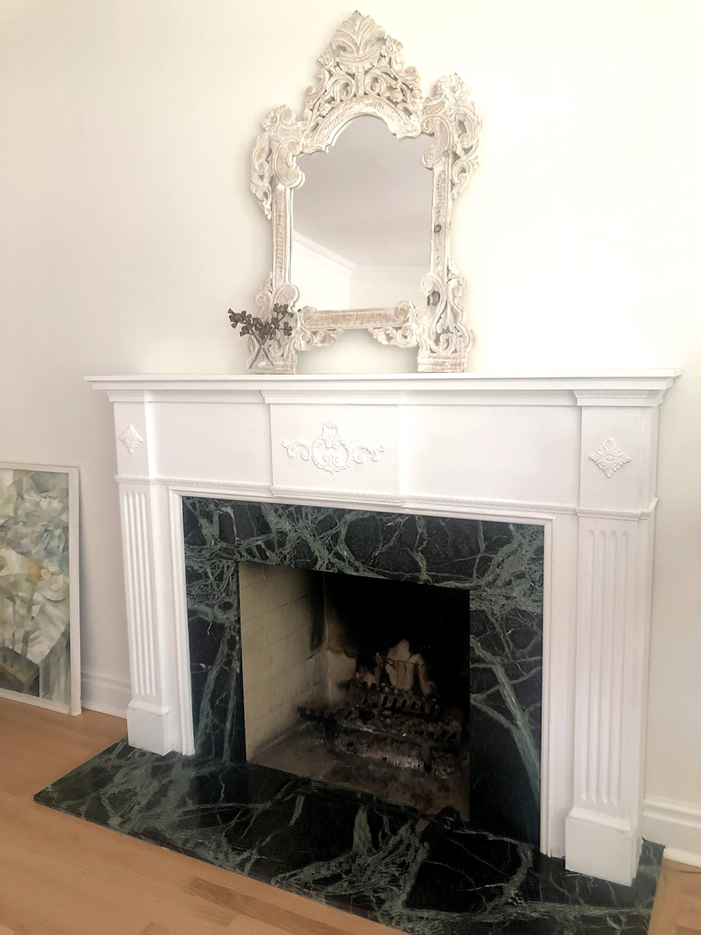 Ornate white fireplace with green marble