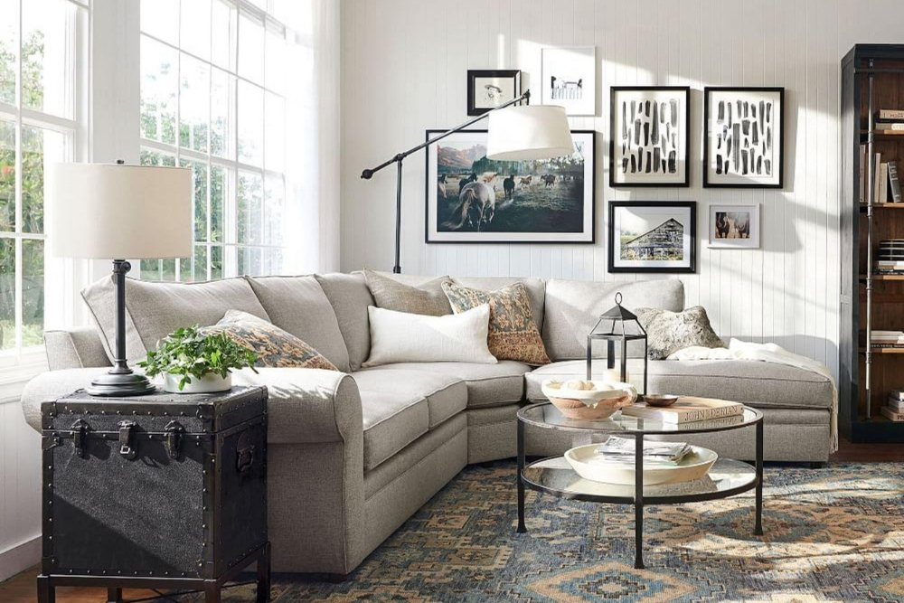 A traditional, white living room with a four seater sectional sofa and a gallery wall.