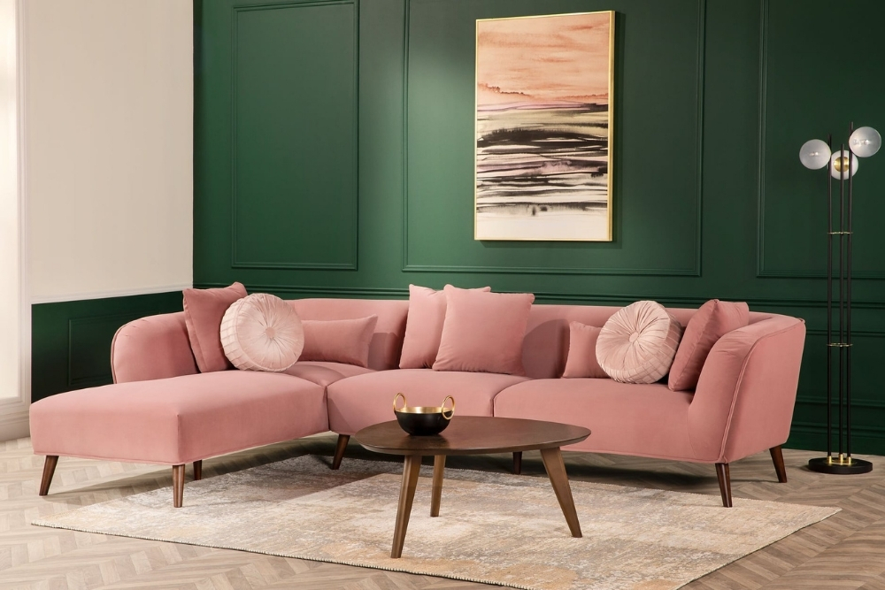 A midcentury-style, velvet pink L-shaped sectional.