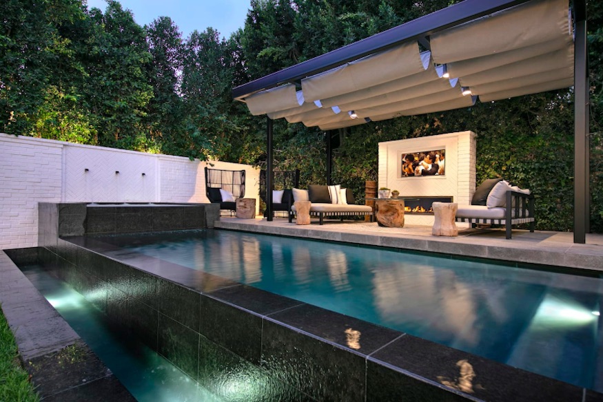 A zero-edge swimming pool in the backyard of the property