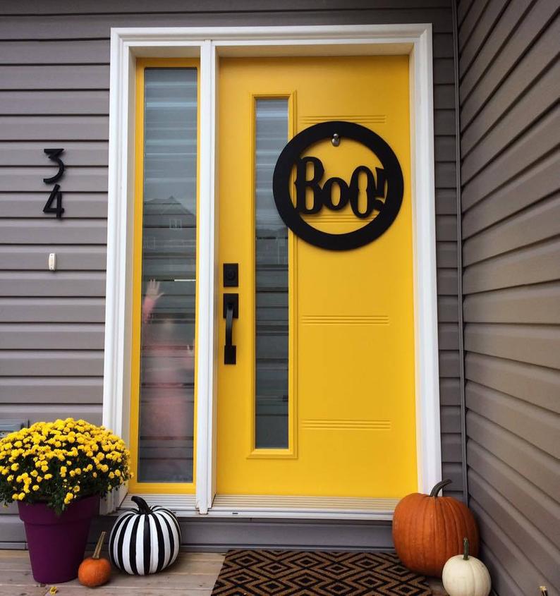 A bright yellow doorway with various Halloween decor