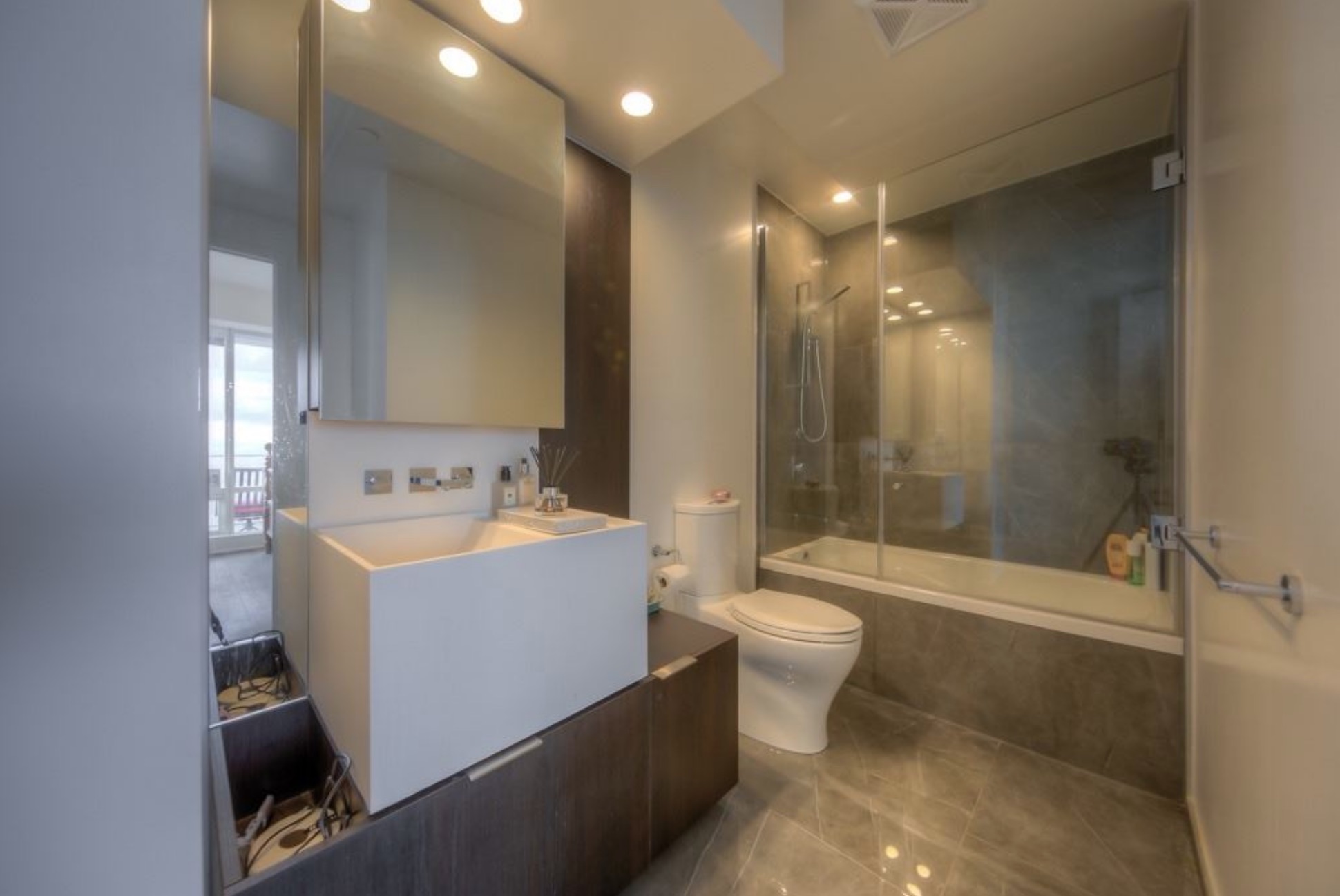 The master bathroom with a glass-enclosed shower-tub combo