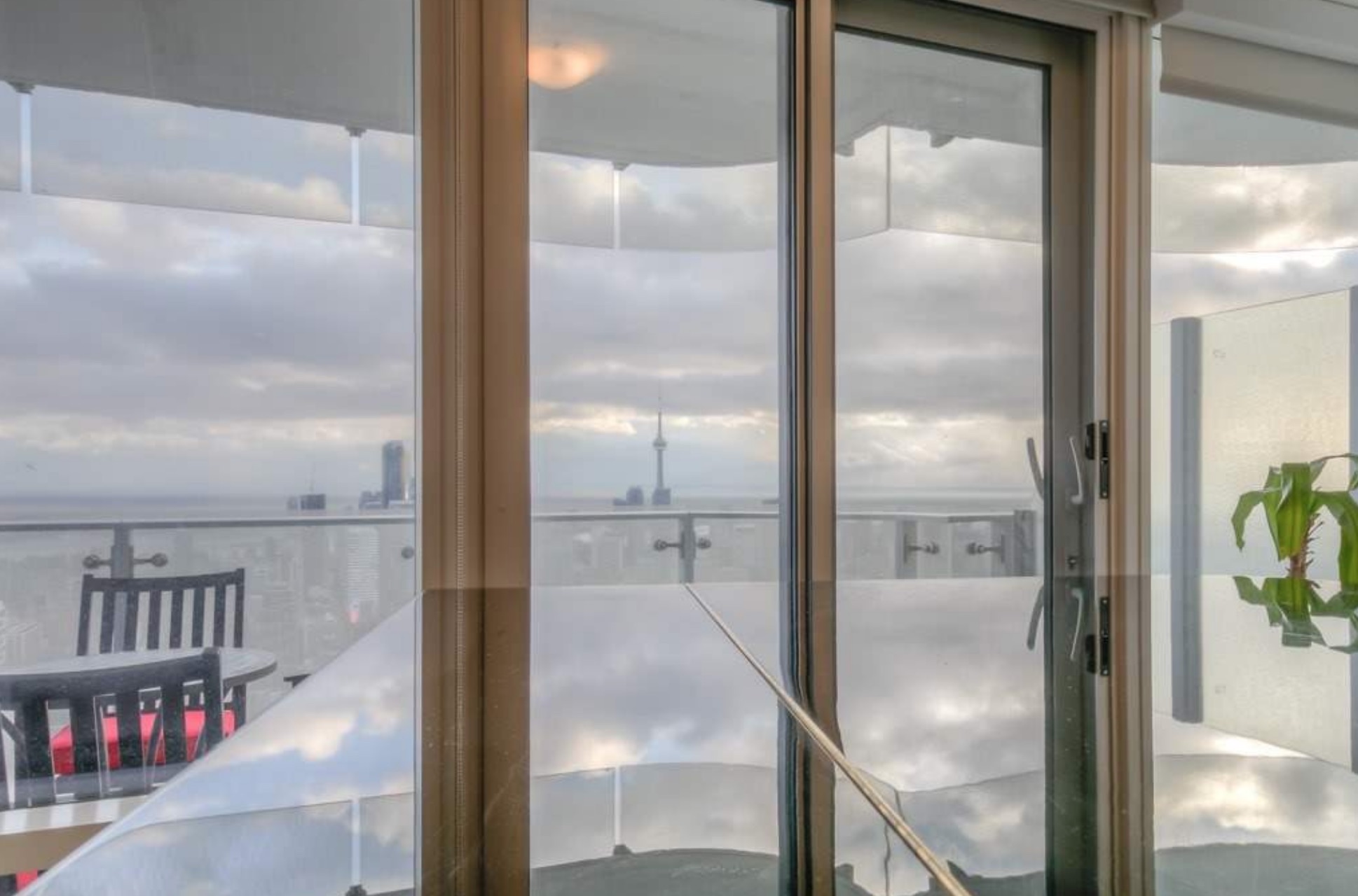 Floor-to-ceiling windows that reflect the CN Tower in the distance
