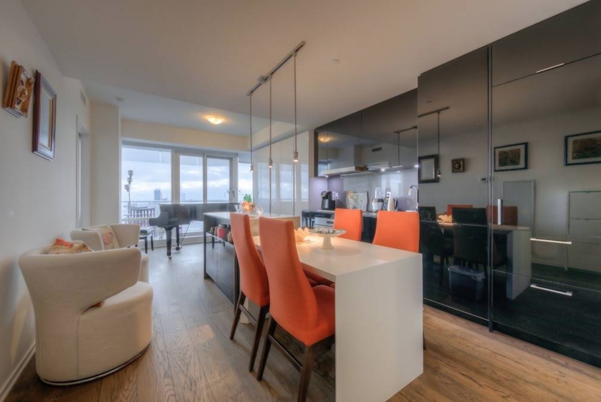 One-bedroom condo unit with white kitchen island and large black cabinets and cabinetry