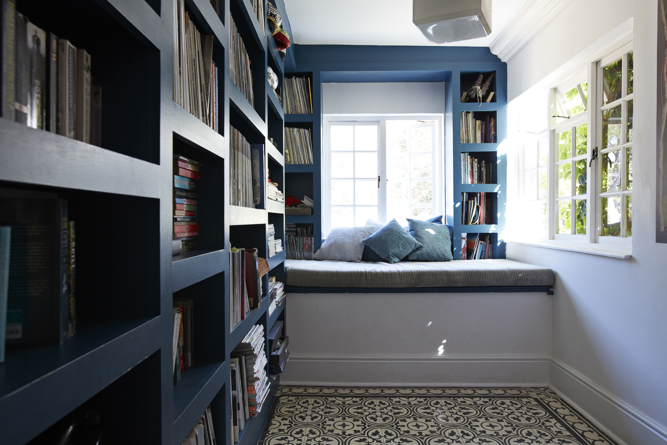 Blue bookshelves in small room with open window
