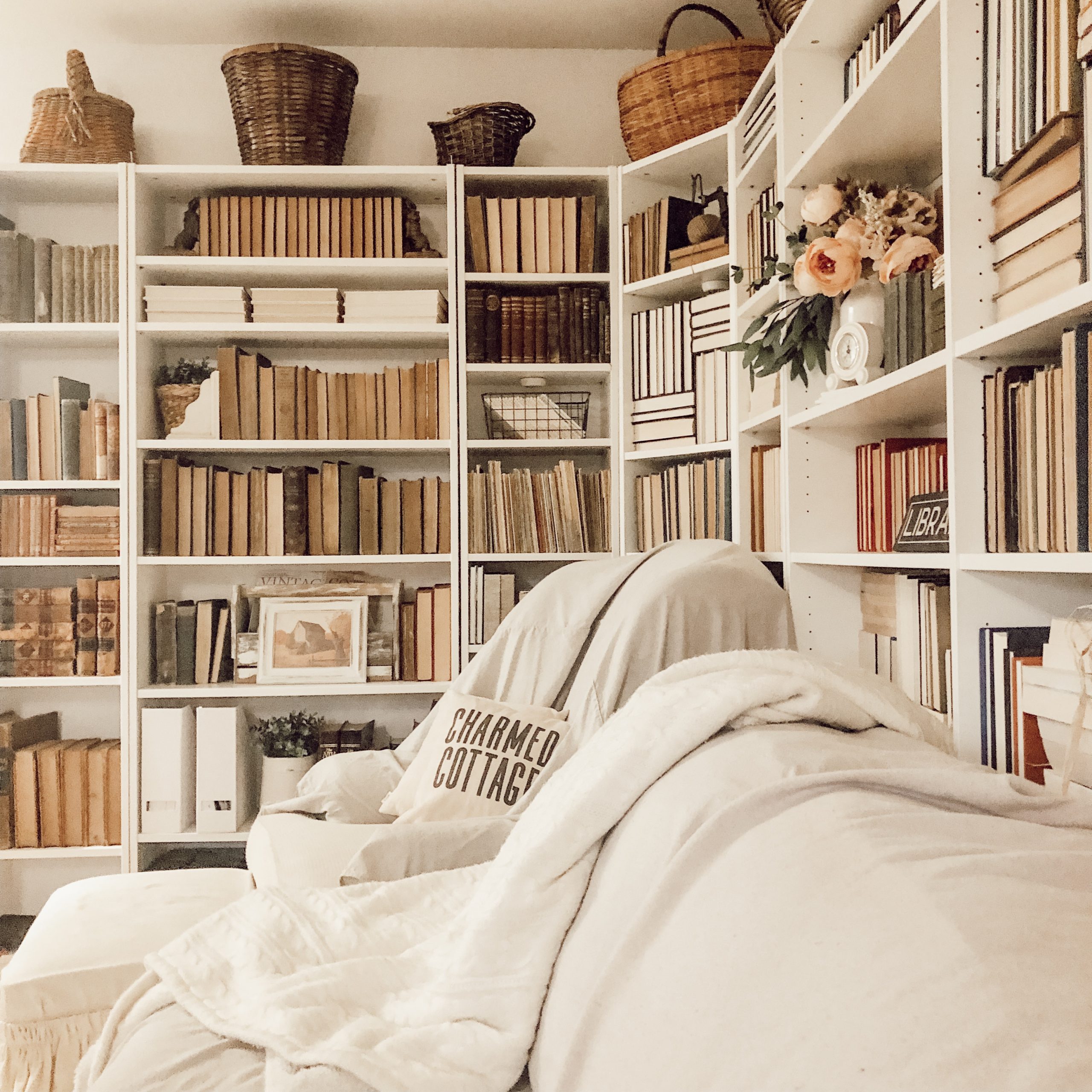 Books on shelves with their spines turned inward in a neutral cottage setting