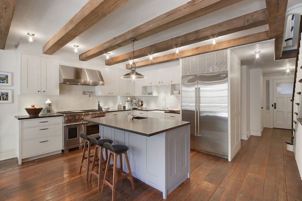white kitchen with stainless steel appliances and exposed ceiling beams