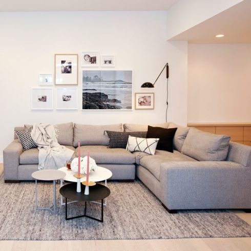 A grey area rug in a basement living room