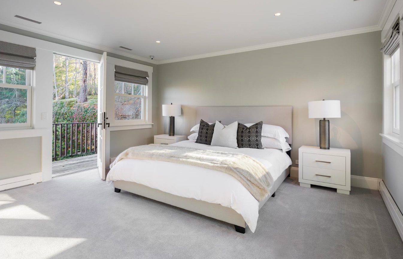 A simple white and grey guest bedroom with it's own private patio