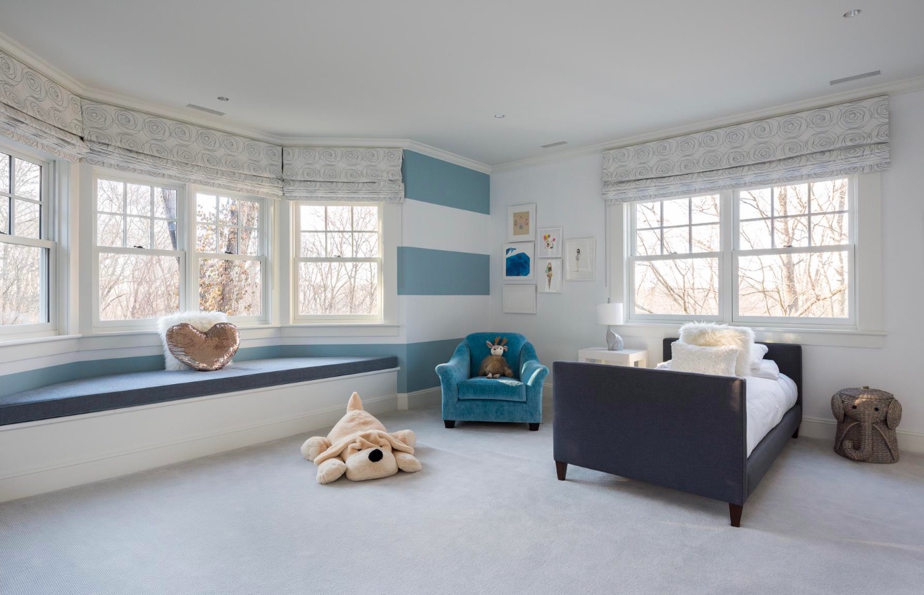 A sitting area beneath a bay window in a child's bedroom
