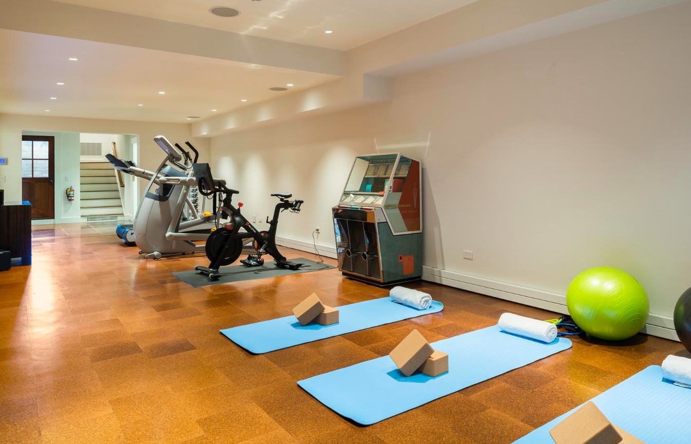A cork-floored gym room with yoga mats and exercise equipment