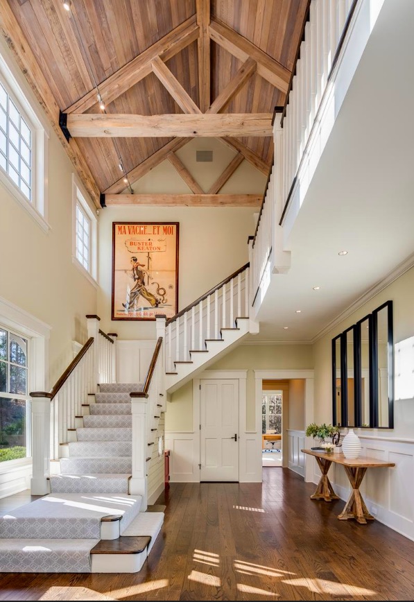 A winding carpeted staircase in the entry foyer leads to the second level of this rustic home