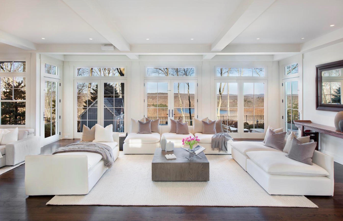 Multiple sets of French doors in the spacious white living room with plenty of windows