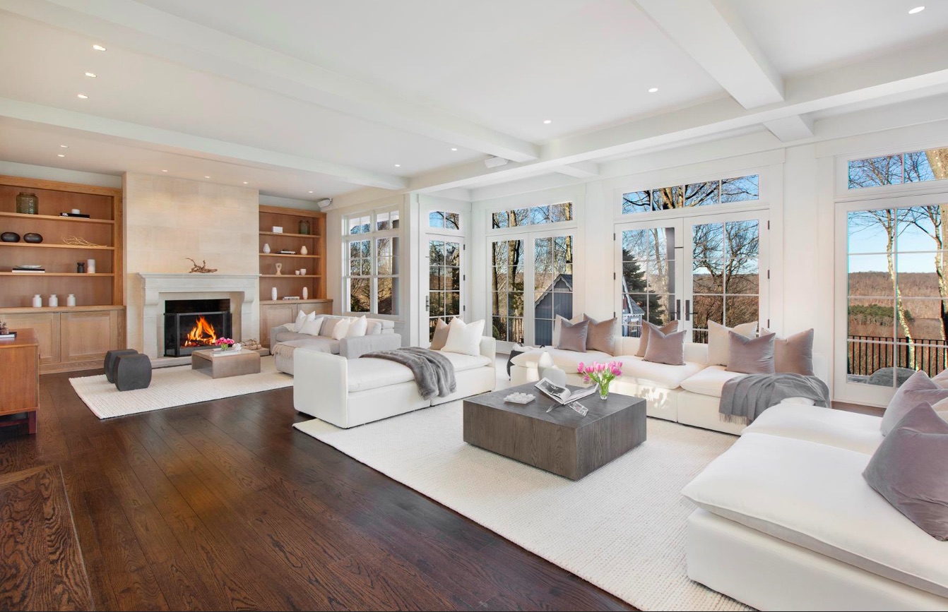 Spacious white living room with hardwood flooring and plenty of light coming in from the windows