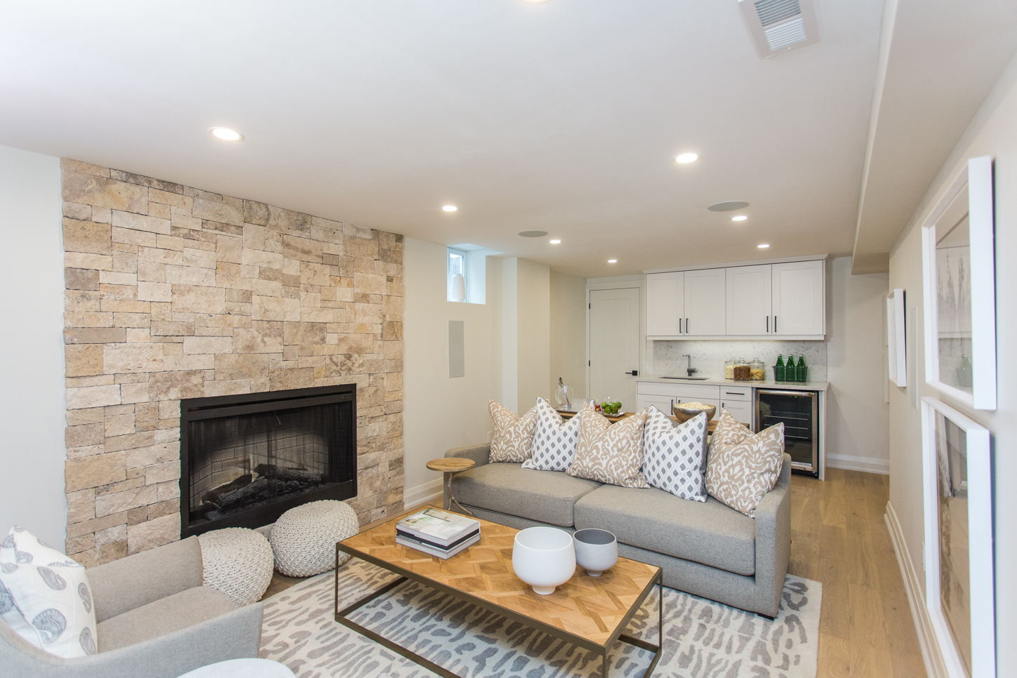 Contemporary basement with stone fireplace wall and neutral colours