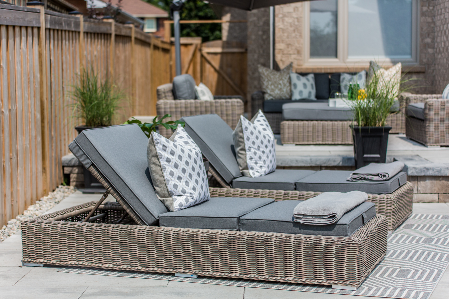 Wicker lounge beds with decorative grey cushions