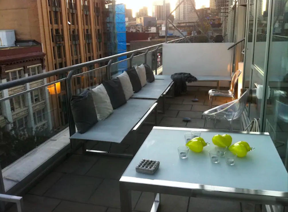 Loft penthouse deck with modern luxury lounge chairs and seating that overlooks the city