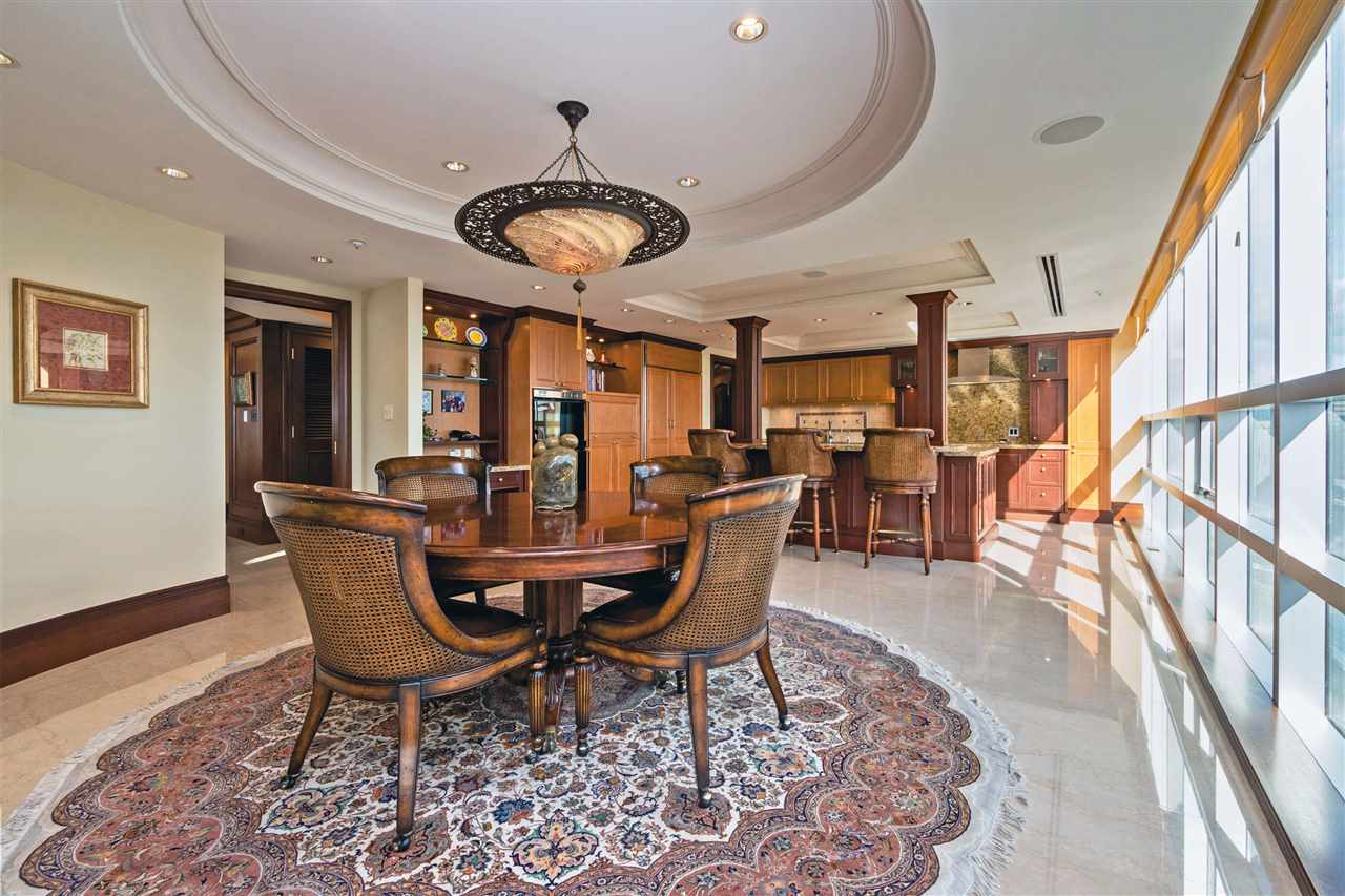 dining area with gleaming marble floors and a coffered ceiling