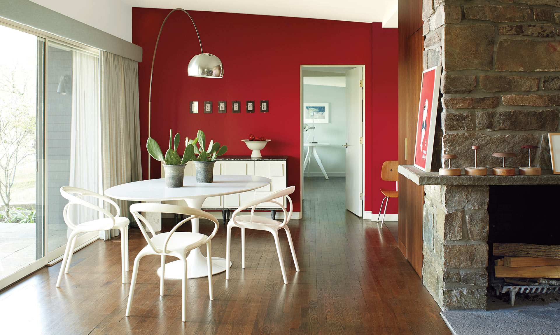 Modern dining room design with bright red accent wall.