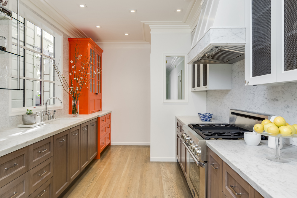 Bright kitchen with neon orange hutch.
