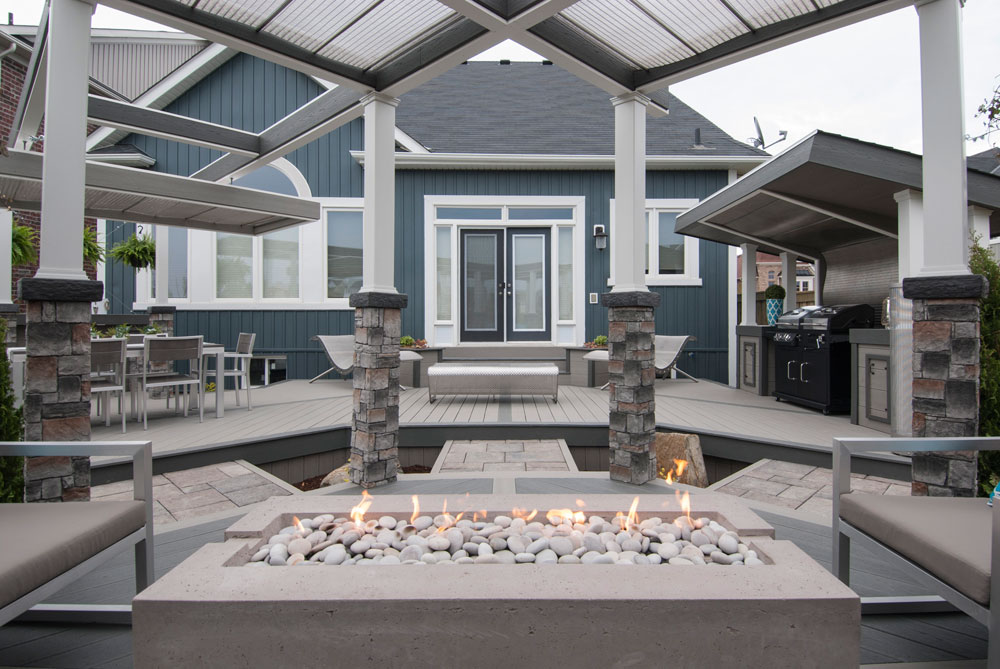 Hardscaped patio design with dining and lounge areas, along with modern fire pit.
