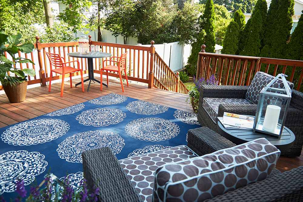 Deck design with punchy navy damask rug and bright furniture.