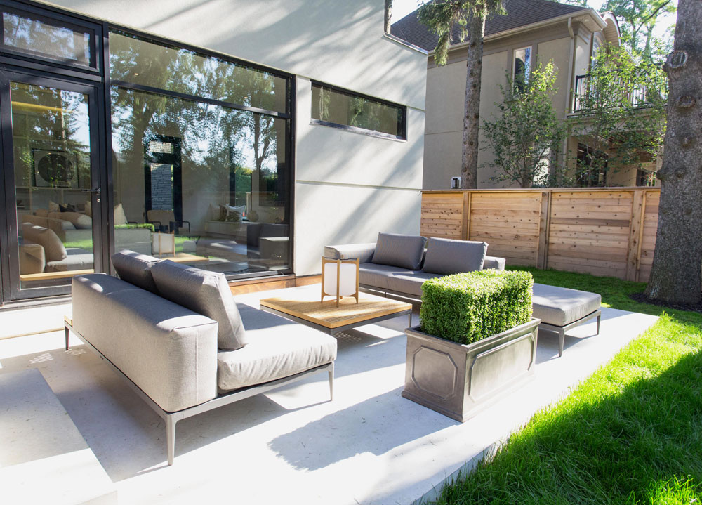 Modern backyard lounge area with stylish low-slung furnishings that suit indoors.
