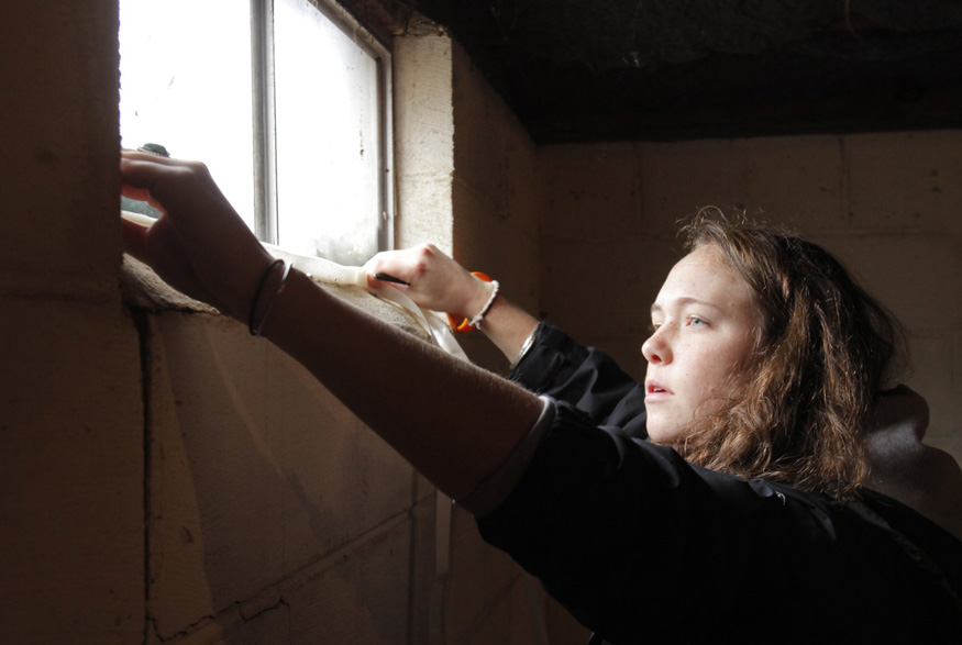 Woman insulating around windows