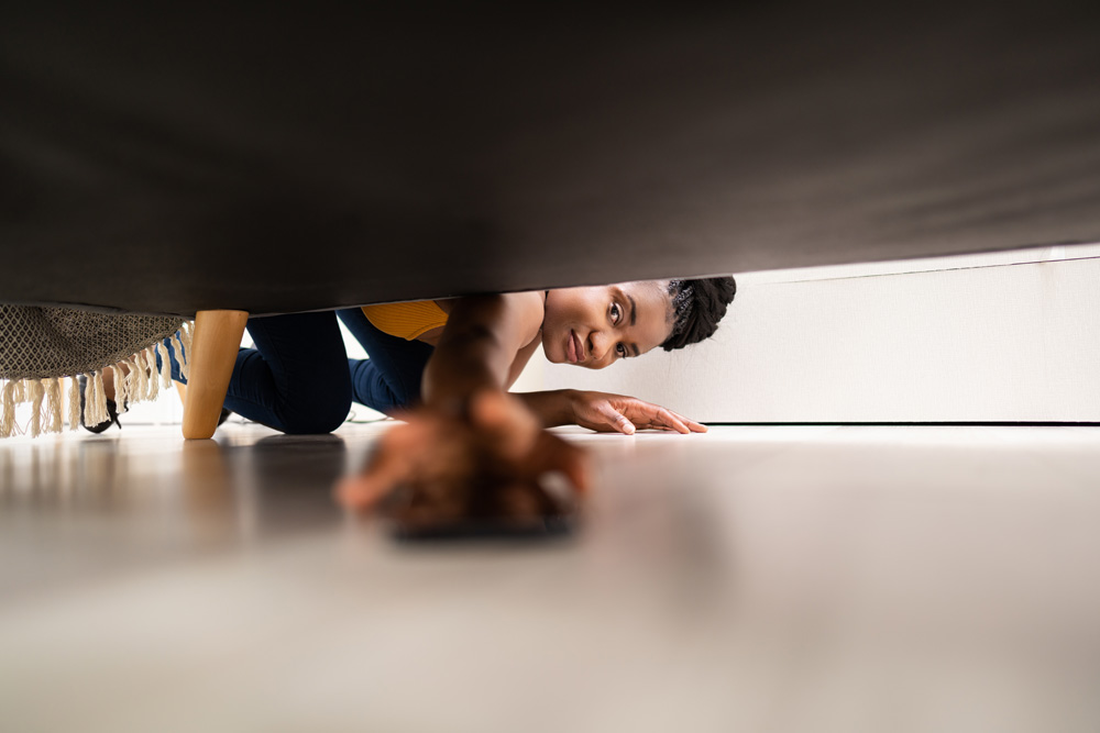 Person looking under a couch