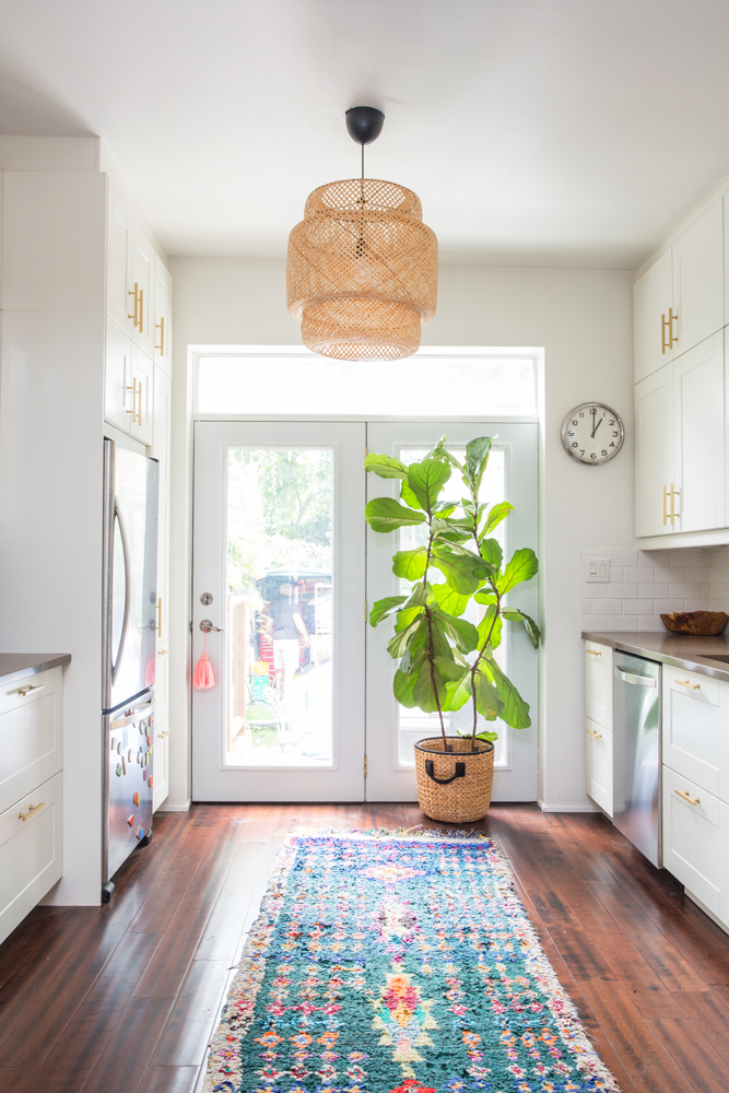 galley kitchen with rattan chandelier, nubby runner and big potted plant