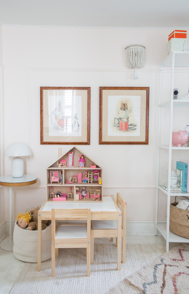 girl's room with play table, two chairs and dollhouse with pink furniture