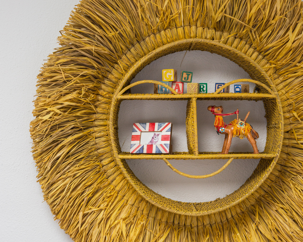 closeup woven circular wall hanging with giraffe, union jack frame and alphabet blocks inside