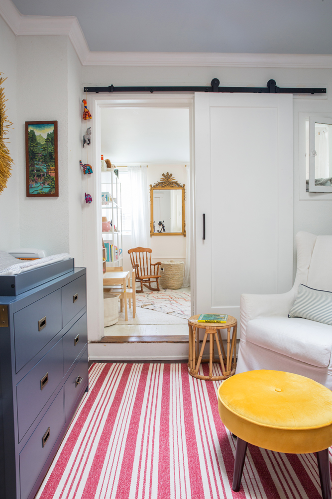 kids room with sliding door, blue dress, yellow stool, red striped rug