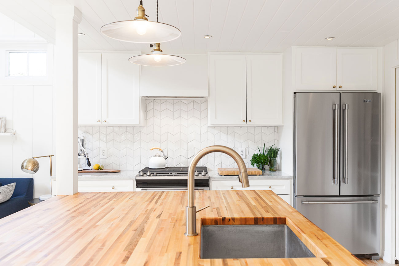 Bright white kitchen with stylish brass hardware.