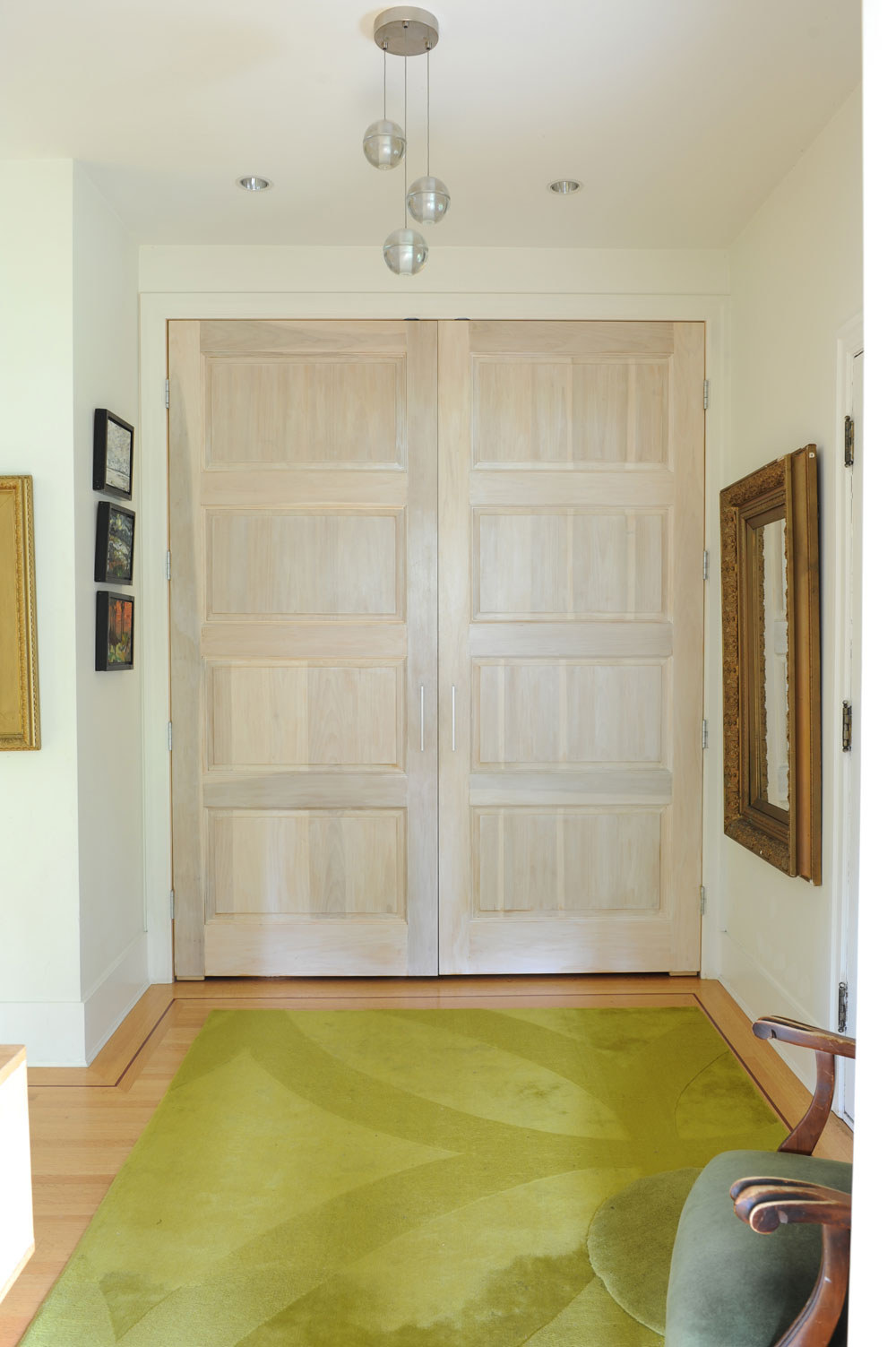 Double white oak panelled doors in front of green rug