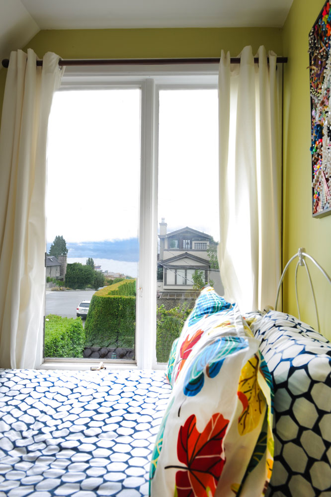 Bedroom window view with blue and white bedspread