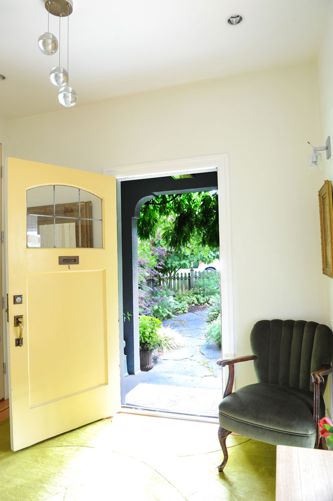 Yellow front door open to hallway