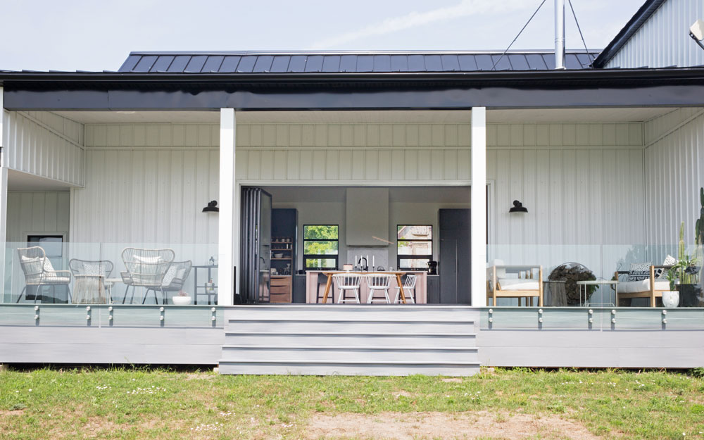 exterior view of entire modern barn porch with interior dining table in middle