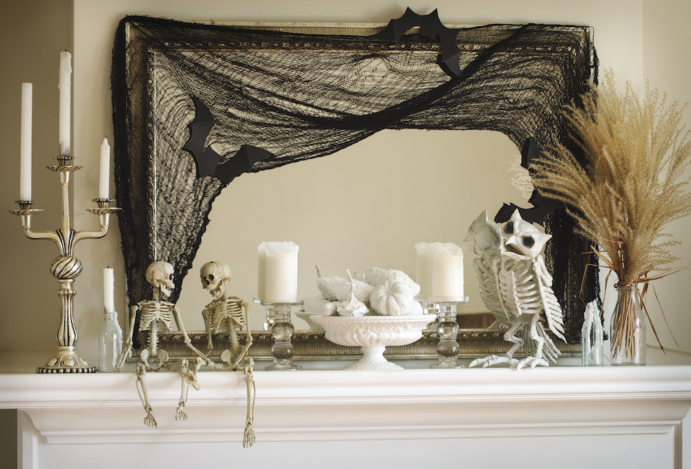 white mantle with painted white mini gourds and halloween decorations