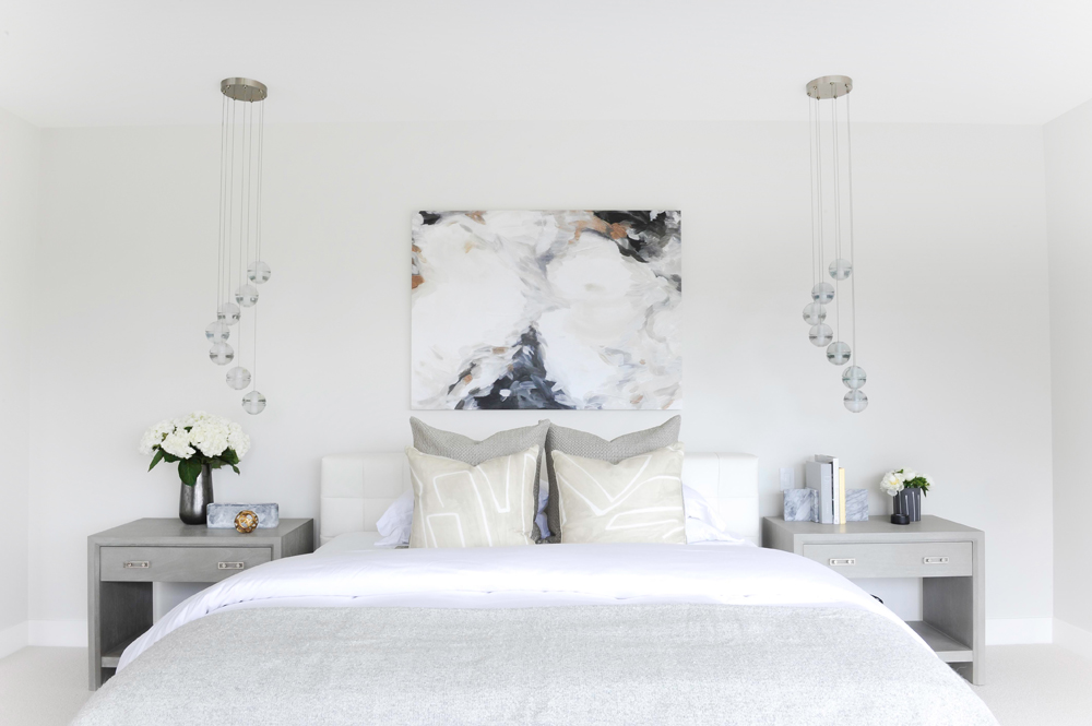 Modern bedroom with artwork and grey side tables