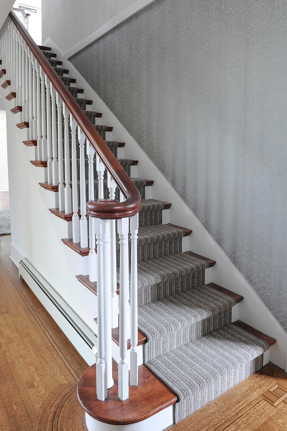 A striped runner adds depth and warmth to the staircase and nicely plays up the original inlay details in the floor.