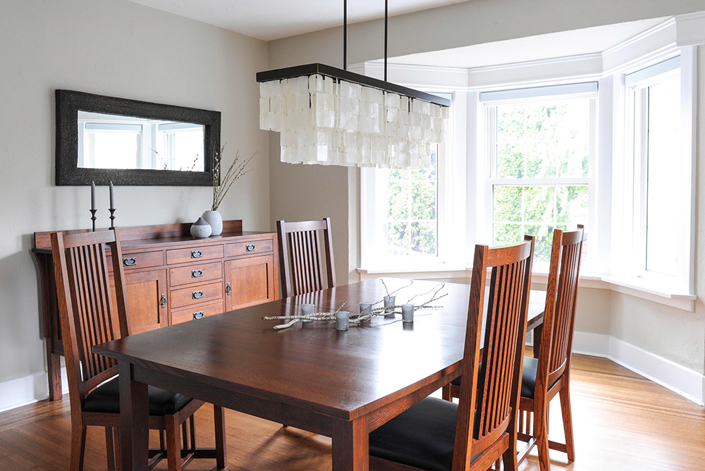Dark wood dining table and chairs uplifted with breezy modern light fixture.