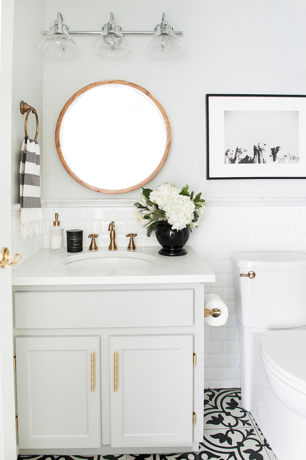 Monochromatic bathroom punched up with black and brass accents.