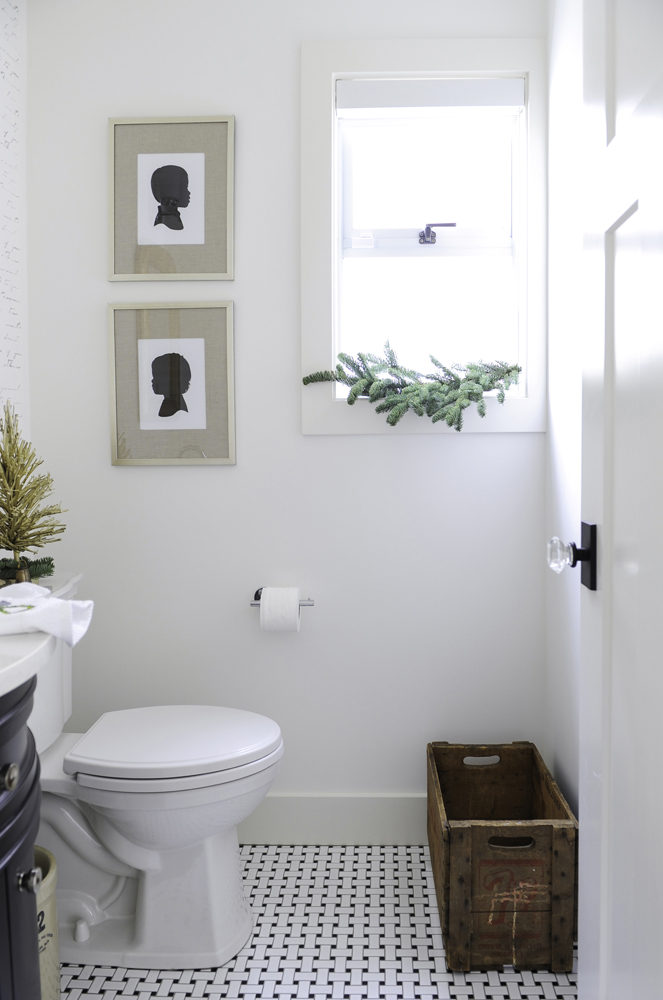 Vintage-style powder room with bough of greenery on the windowsill.