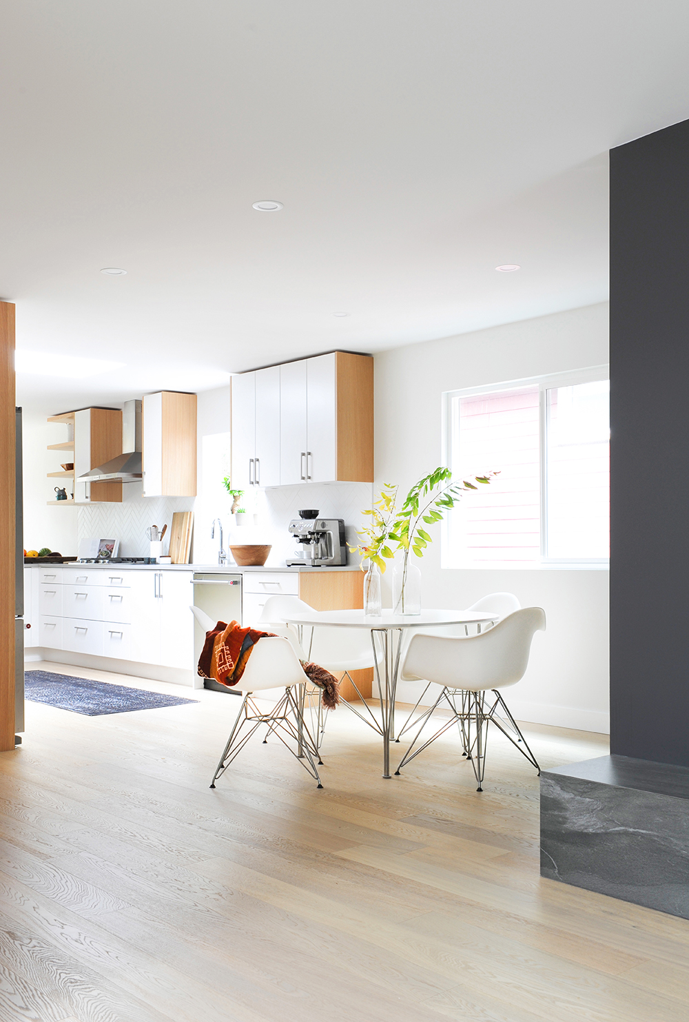 Varying wood tones animate the mostly white kitchen.