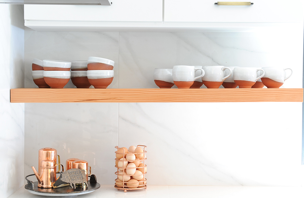 wood shelf beneath cupboards with bowls and cups