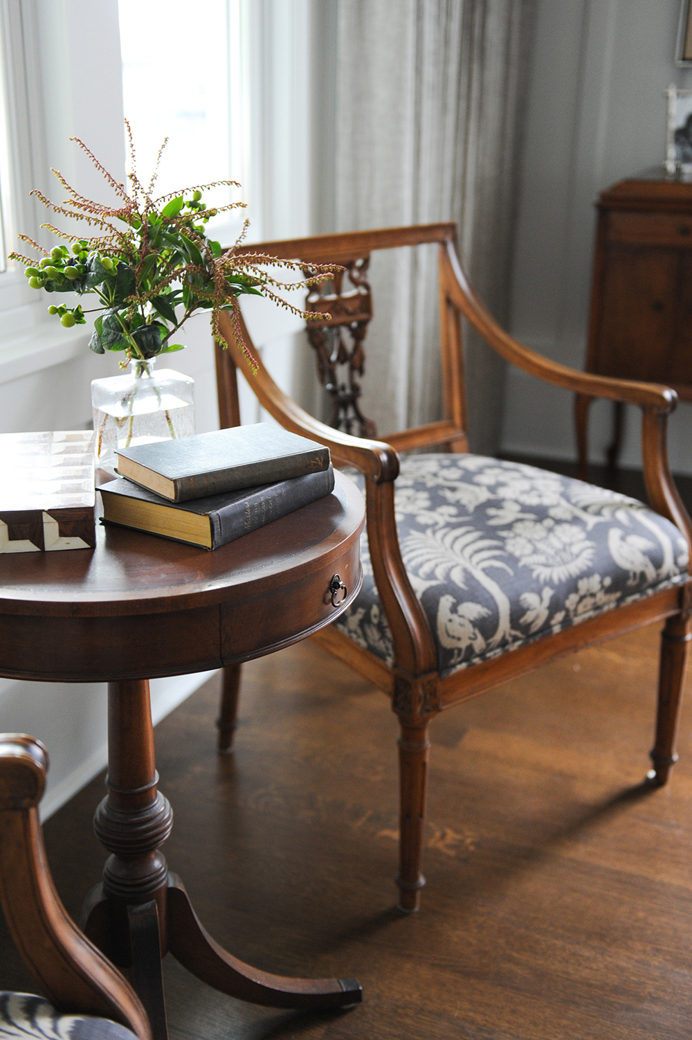An antique chair upholstered in a lively patterned fabric.